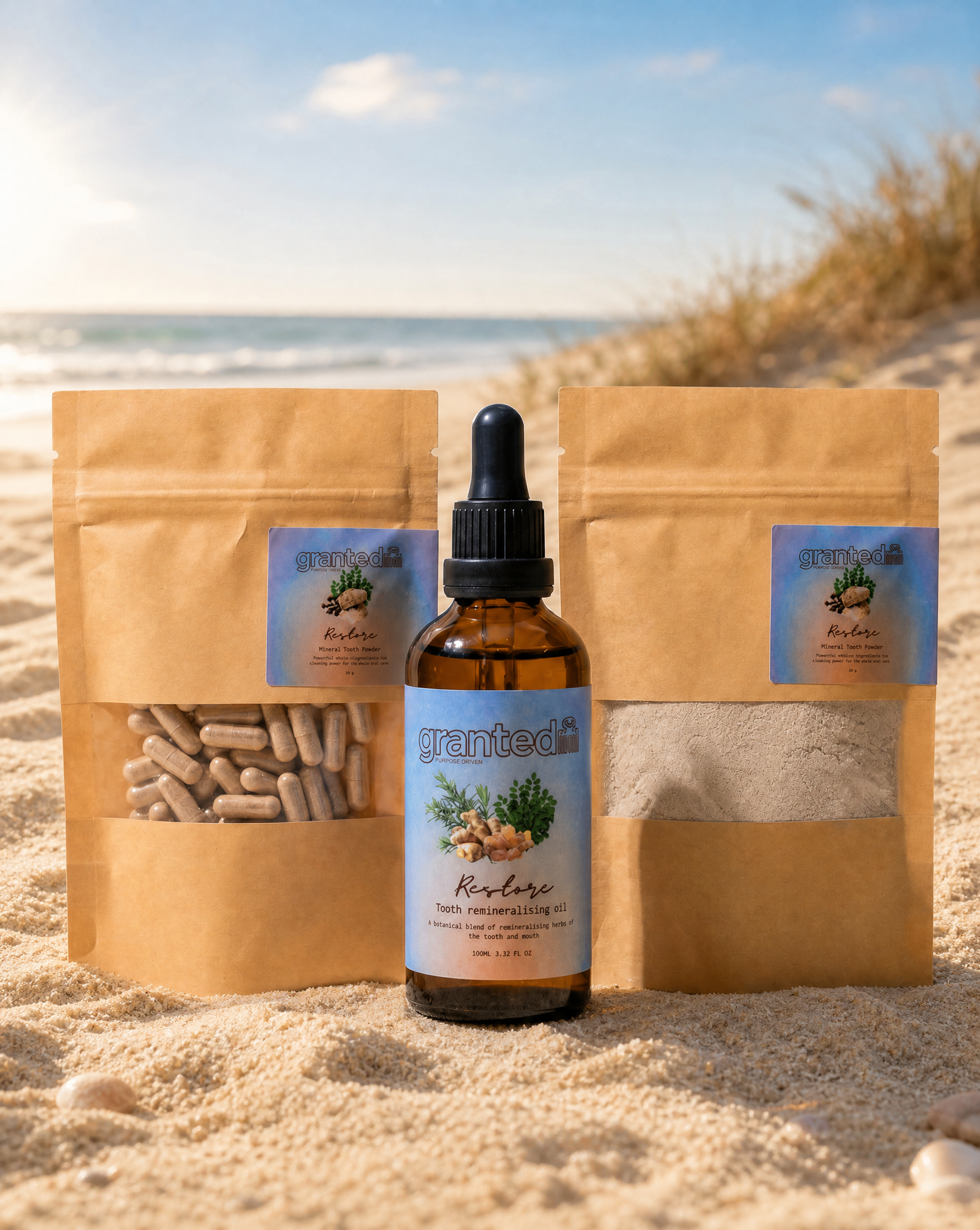 Bottle of Grantea product with two brown packages on a sandy beach